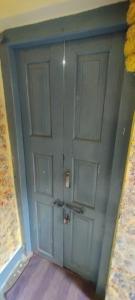 a green door in a corner of a room at Sri Viswanatham Guest House in Varanasi