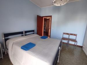 a bedroom with a bed with two blue pillows on it at La Riva in Porto Recanati