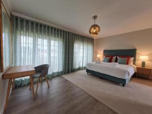 - une chambre avec un grand lit, un bureau et une table dans l'établissement Casa Da Luz Villa - Praia D'El Rey Golf Resort, à Casal da Lagoa Seca