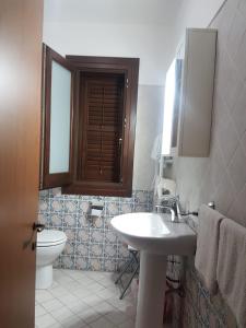 a bathroom with a sink and a toilet at Ippocampo B&B in Licata