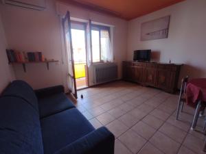 a living room with a blue couch and a tv at La Riva in Porto Recanati