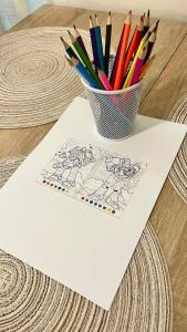 a cup of colored pencils sitting on top of a paper at Comfort Place Brno Apartments in Brno