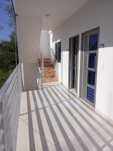 een wit huis met een trap naar een deur bij Apartamentos Mi Reserva OK - Miraluna in Coveñas