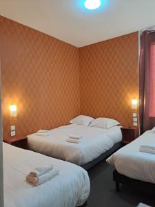 a hotel room with two beds with towels on them at hôtel le Celtic Montluçon in Montluçon