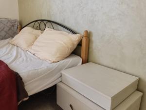 Cama pequeña con almohada blanca y mesita de noche en Sebstian Rooms en Madaba