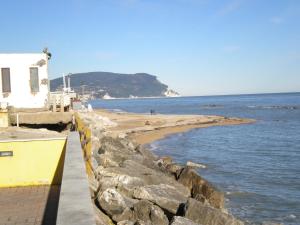 a beach with a white building and the ocean at La Riva in Porto Recanati