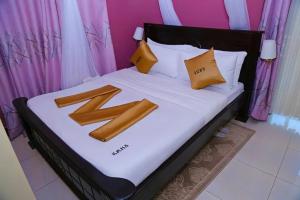 a bed with two pillows on it with at Jade Spa and Hotel in Kasese