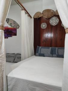 uma cama com cortinas brancas e uma cabeceira em madeira em #Apartamento aconchegante no Flamengo - RIO no Rio de Janeiro