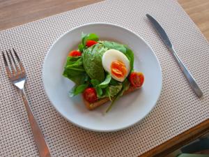 un plato blanco con una ensalada y un huevo en la parte superior en Hotel Ajax en Punta del Este