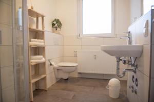 een badkamer met een toilet, een wastafel en een raam bij Landgut Stemmen in Stemmen