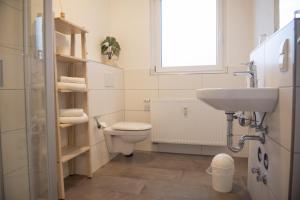 a bathroom with a toilet and a sink and a window at Landgut Stemmen in Stemmen