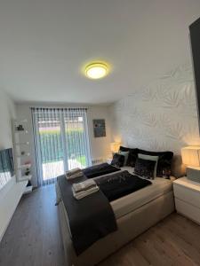 a bedroom with a large bed and a window at Luxus Partivilla Apartman in Szántód