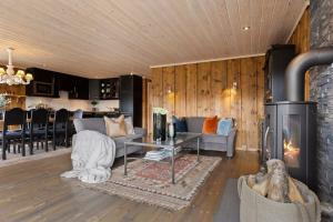 a living room with a fireplace and a couch at Family-friendly cabin at Hemsedal w sauna, skiing & golf at your doorstep in Gol