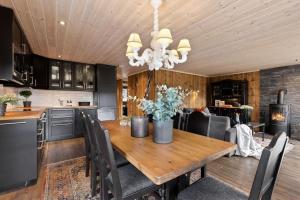 cocina y comedor con mesa de madera en Cozy cabin with sauna, ski tracks and golf outside, en Gol