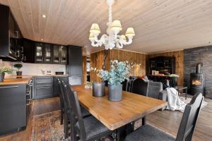 a kitchen and dining room with a wooden table at Family-friendly cabin at Hemsedal w sauna, skiing & golf at your doorstep in Gol