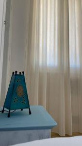 un libro azul sentado en una cama junto a una cortina en Nomads Hostel Tunisia en Túnez