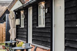 two tables on the side of a black house at The Dukes in Leighton Buzzard