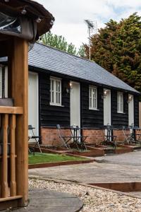 un edificio con mesas y sillas delante de él en The Dukes en Leighton Buzzard