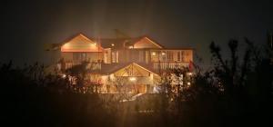 a large house is lit up at night at Viva Villa in Jhājra
