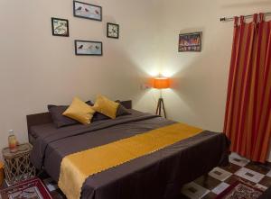 Viva Villa في Jhājra: غرفة نوم بسرير كبير وستارة حمراء