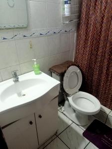 a bathroom with a white toilet and a sink at Habitaciones Pabla in Santiago