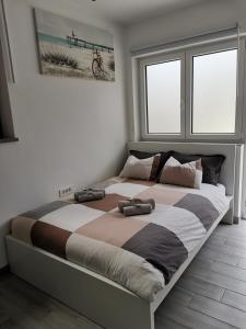 Una cama grande en un dormitorio con dos zapatos. en Apartma Pinea, en Portorož