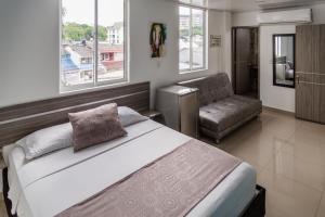 1 dormitorio con 1 cama grande y 1 silla en Casa del Sol en Villavicencio