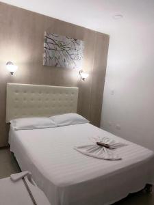 un letto bianco con un piatto sopra di HOTEL NUEVO ARIZONA a Cartagena de Indias