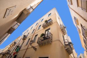 un edificio alto con balcones y ventanas. en BADIA NUOVA Apart Hotel, en Trapani