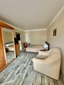 a room with two beds and a couch and a mirror at Apartment Budivelnykiv 22/11 in Kyiv