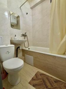 a bathroom with a toilet and a sink and a tub at Apartment Budivelnykiv 22/11 in Kyiv
