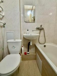 a bathroom with a white toilet and a sink at Apartment Budivelnykiv 22/11 in Kyiv