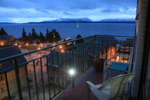 einen Balkon mit Meerblick in der Nacht in der Unterkunft LUMINOSO FUNCIONAL. UBICACION Y VISTA INMEJORABLES in San Carlos de Bariloche