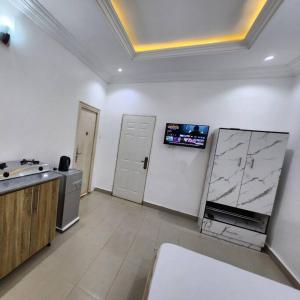 Il comprend une cuisine avec un évier et une télévision murale. dans l'établissement Asfranz Studio Apartment, à Abuja