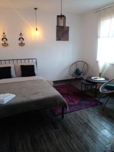 1 dormitorio con 1 cama, mesa y sillas en Apartman Nej&Se Ravne, en Visoko