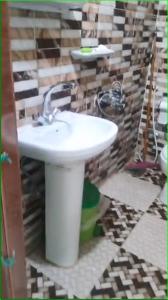 La salle de bains est pourvue d'un lavabo blanc. dans l'établissement Taam Al beeyout, à Naj‘ al Maḩaţţah