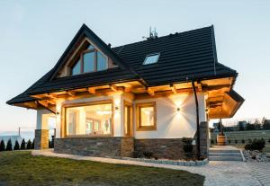 mały dom z czarnym dachem w obiekcie Czorsztyn Ski&Sail Aparthouse w mieście Maniowy