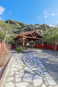 a stone walkway with a wooden pavilion with tables and chairs at Ixia Aqua Vista House in Rhodes Town