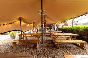 una fila di tavoli e panche in tenda di Bosuns Chair a Lymington