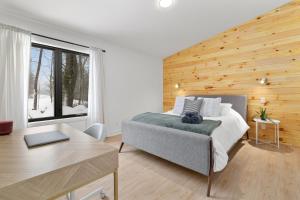 a bedroom with a bed with a wooden wall at Le Singapour - Cottage Resort - Brownsburg-Chatham in Brownsburg