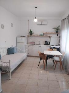 a bedroom with a bed and a table and a kitchen at Studio Rafaela in Matala