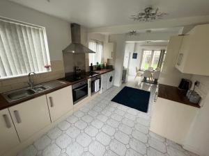 una cucina con lavandino e piano cottura di Zen 8-Bedroom Den in Edgbaston a Birmingham