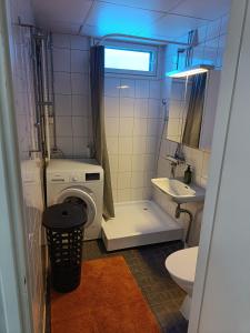 a bathroom with a washing machine and a sink at Lägenhet på markplan in Mariehamn