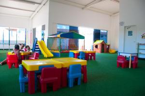 una sala de juegos para niños con mesas y sillas coloridas en Lacqua Diroma Loc Caldas en Caldas Novas