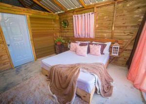 - une chambre avec un lit dans une cabane en bois dans l'établissement Vista al Valle, à San Felipe de Puerto Plata