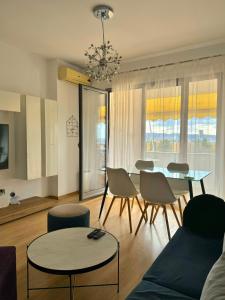 a living room with a couch and a table and chairs at Sunset Apartment in Tirana