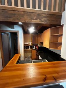 - une cuisine avec des placards en bois et un comptoir dans l'établissement Résidence CERDANYA, à Bourg-Madame