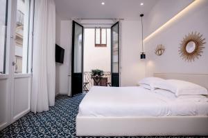 1 dormitorio con cama blanca y ventana en BADIA NUOVA Apart Hotel, en Trapani