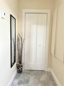 a hallway with a white door and a potted plant at modern rustic apartment in St. John's