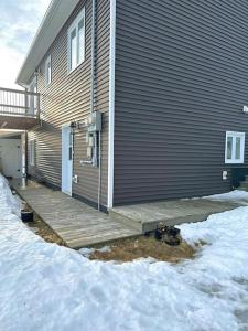 a house with a wooden porch in the snow at modern rustic apartment in St. John's